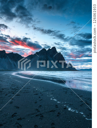 Sunset over volcanic Vestrahorn mountain on black sand beach in summer at Iceland 126861933