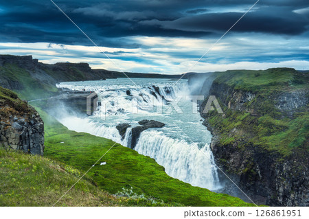 Gullfoss or Golden Falls waterfall flowing in lush canyon and moody sky in summer at Iceland 126861951