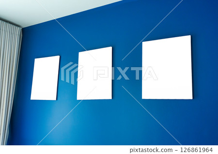 Three empty square canvas frames arranged on deep blue wall Three empty square canvas frames arranged on deep blue wall 126861964