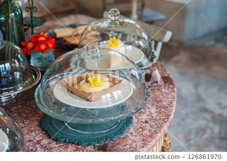 Various desert under glass dome on marble table decorated with antique style 126861970