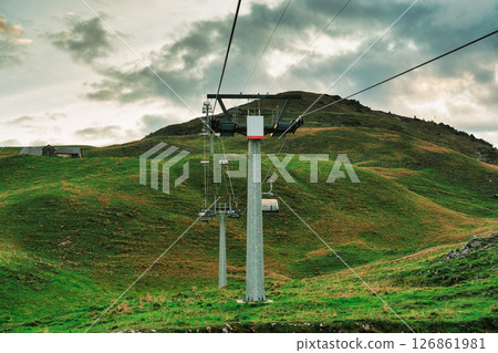 Chairlift or cable car lifting over Stoos village and Swiss Alps mountain in the evening Chairlift or cable car lifting over Stoos village and Swiss Alps mountain in the evening 126861981