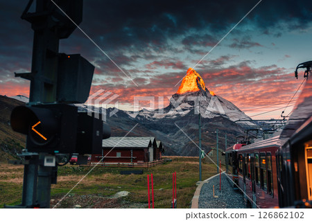 Golden sunrise over Matterhorn mountain during train riding up to Gornergrat station at Zermatt Golden sunrise over Matterhorn mountain during train riding up to Gornergrat station at Zermatt 126862102