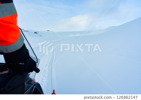 Snowmobile riding through arctic snowy landscape in winter 126862147