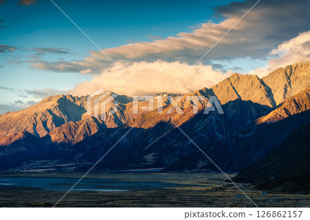 Golden sunrise over rugged rocky mountain range in autumn at New Zealand Golden sunrise over rugged rocky mountain range in autumn at New Zealand 126862157