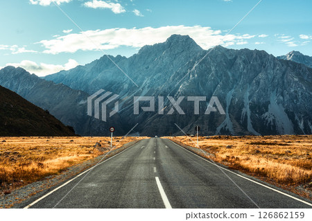 Scenic road to Majestic mountain over golden grassland in New Zealand Scenic road to Majestic mountain over golden grassland in New Zealand 126862159