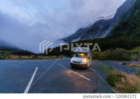 Motorhome parked along quiet road surrounded by misty mountain in rainforest national park 126862171