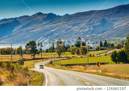 Scenic rural road trip with winding road, mountain, sheep farm and lake during autumn at New Zealand Scenic rural road trip with winding road, mountain, sheep farm and lake during autumn at New Zealand 126862197