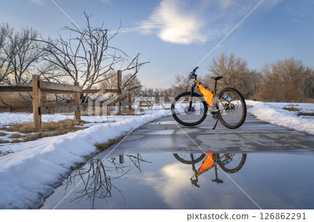 mountain bike on Poudre River Trail near Greeley in Colorado, winter scenery with puddle reflection mountain bike on Poudre River Trail near Greeley in Colorado, winter scenery with puddle reflection 126862291