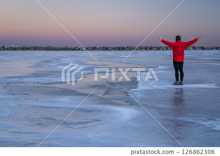 lonely male figure on a frozen lake at dusk in Colorado - Boyd Lake State Park lonely male figure on a frozen lake at dusk in Colorado - Boyd Lake State Park 126862306