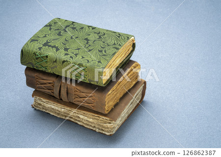 stack of retro  journals with decked edge handmade paper pages, journaling concept 126862387