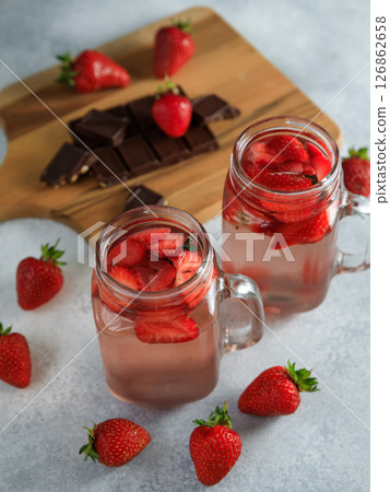 Detox drink withstrawberry berries and wooden board with dark chocolate. Detox drink withstrawberry berries and wooden board with dark chocolate. 126862658
