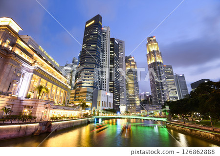 Building view of the Fullerton Hotel, Cavenagh Bridge, and financial district skyscrapers along the Singapore River. 126862888