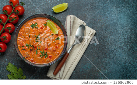 Brazilian traditional dish moqueca de camarao with shrimps, tomatoes, peppers, and lime in a bowl top view, space for text Brazilian traditional dish moqueca de camarao with shrimps, tomatoes, peppers, and lime in a bowl top view, space for text 126862903