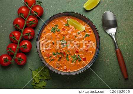 Brazilian traditional dish moqueca de camarao with shrimps, tomatoes, peppers, and lime in a bowl top view 126862906