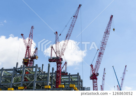 Low-angle view of cranes and steel structures of building construction with a blue sky background in Taiwan. 126863052