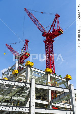 Low-angle view of cranes and steel structures of building construction with a blue sky background in Taiwan. 126863060