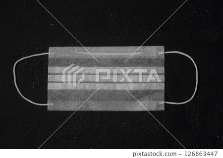Disposable medical mask isolated on black background 126863447