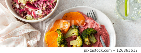 A nutritious morning meal featuring sweet potato, broccoli, radish salad with chia seeds and beet hummus for a balanced, protein-packed start, banner 126863612