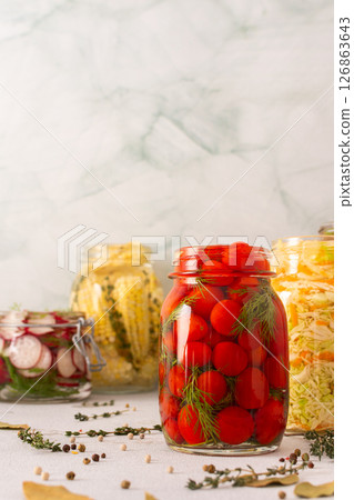 Fresh red tomatoes fermenting in a jar with spices, creating a healthy probiotic-rich food, fresh fermenting vegetables like radishes, corn, cabbage 126863643
