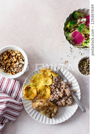 A nutritious, balanced breakfast featuring green buckwheat, fried hake, zucchini, and a fresh broccoli salad with pink radish, seeds, and nuts, offering a wholesome start to the day A nutritious, balanced breakfast featuring green buckwheat, fried hake, zucchini, and a fresh broccoli salad with pink radish, seeds, and nuts, offering a wholesome start to the day 126863684