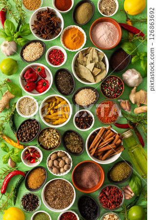 Brightly colored spices and herbs arranged on a delicate green background, highlighting their freshness and fragrance for a lively, natural look Brightly colored spices and herbs arranged on a delicate green background, highlighting their freshness and fragrance for a lively, natural look 126863692