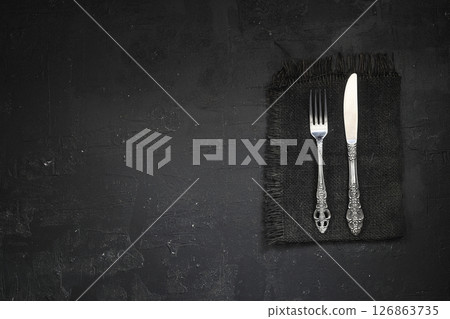 Overhead shot of silverware on black table with copy space. Overhead shot of silverware on black table with copy space. 126863735