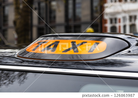 Classic London Black Taxi Roof Sign, Iconic Orange TAXI Sign on Traditional Cab 126863987
