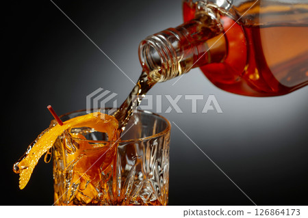 Whiskey or bourbon pouring into a crystal glass. 126864173