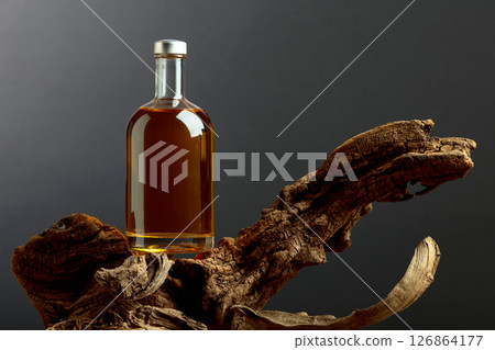Bottle of whiskey on a old snags. Bottle of whiskey on a old snags. 126864177