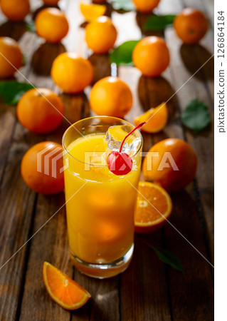 Orange juice and fresh fruits on an old wooden table. 126864184