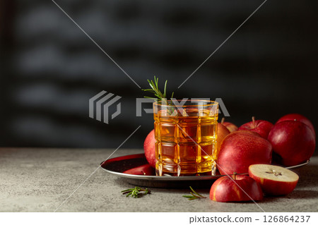 Apple juice and fresh apples on an old kitchen table. Apple juice and fresh apples on an old kitchen table. 126864237