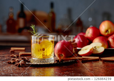 Apple cider with apple slices and a rosemary sprig. Apple cider with apple slices and a rosemary sprig. 126864239