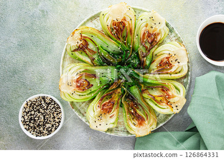 Grilled bok choy served with soy sauce and sesame seeds, on a white plate, homemade, no people, 126864331