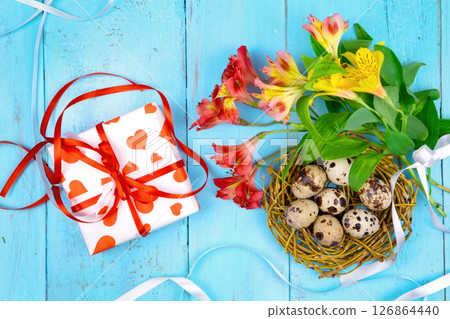 Spring background. Bouquet of flowers on a wooden background and a nest with eggs. spring Spring background. Bouquet of flowers on a wooden background and a nest with eggs. spring 126864440