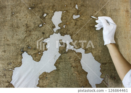 restoration and conservation of a very old canvas, restoration of a painting, restorer at work, place for text 126864461