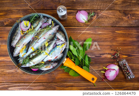 fresh fish perch in a saucepan with spices, top view. place for text 126864470