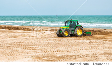 Spain, Valencia, March 29, 2024: Tractor Leveling Sand on a Beach by the Ocean on a Clear Day Spain, Valencia, March 29, 2024: Tractor Leveling Sand on a Beach by the Ocean on a Clear Day 126864545