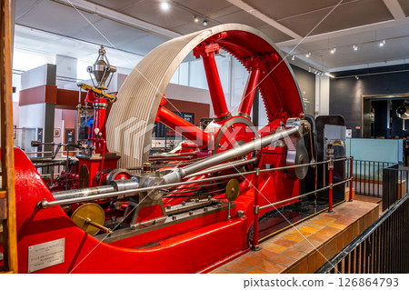 A large red mill engine by Burnley Ironworks Company is showcased at London's Science Museum. Visitors can observe this impressive piece of engineering from various angles. 126864793