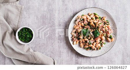 Protein tuna, beans, herb salad on a plate on the table top view web banner 126864827
