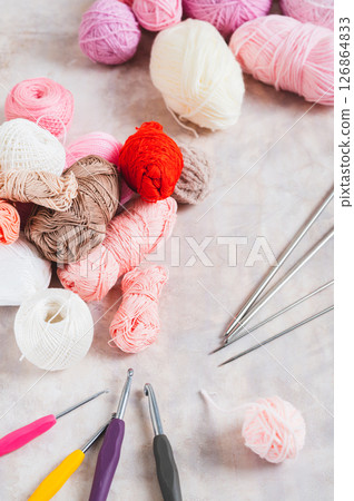 Yarn and tools for a cozy home knitting hobby on the table vertical view 126864833