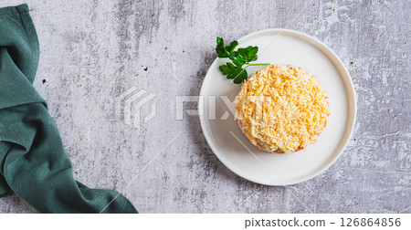 Classic mimosa salad with canned fish and vegetables on a plate on the table top view web banner 126864856