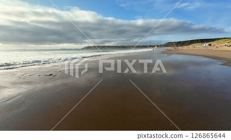Experience a Serene and Tranquil Beach Scene with Calm Waves and a Scenic, Bright Sky Experience a Serene and Tranquil Beach Scene with Calm Waves and a Scenic, Bright Sky 126865644