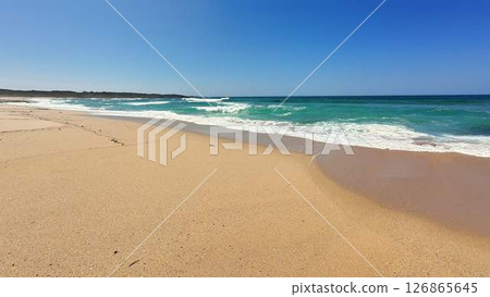 A Beautiful and Peaceful Beach Landscape Featuring Clear Blue Waters and a Sandy Shoreline A Beautiful and Peaceful Beach Landscape Featuring Clear Blue Waters and a Sandy Shoreline 126865645