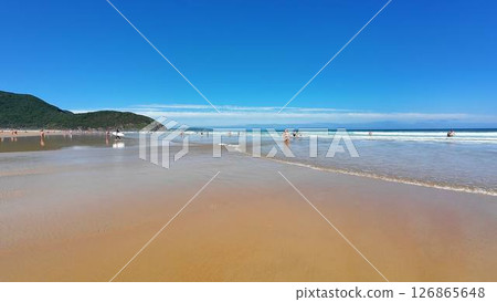 Enjoying the breathtaking Scenic Beach View with a Clear Blue Sky, Gentle Waves Lapping Enjoying the breathtaking Scenic Beach View with a Clear Blue Sky, Gentle Waves Lapping 126865648