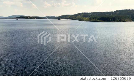 The Serene Waters of a Tranquil Lake are beautifully accompanied by Lush Surroundings all around The Serene Waters of a Tranquil Lake are beautifully accompanied by Lush Surroundings all around 126865659