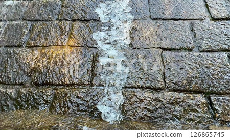 The Flowing Water Moving Over a Smooth Stone Surface Within a Beautiful Natural Environment 126865745
