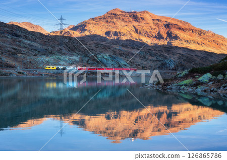 Bernina express train and alpine lake with colorful reflections 126865786