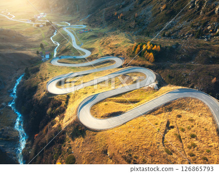 Aerial view of winding mountain road, river in alpine valley 126865793
