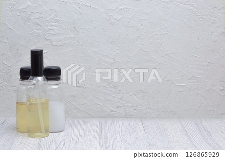 Side view of shampoo and conditioner on a light surface, with ample copyspace for promotional content. 126865929