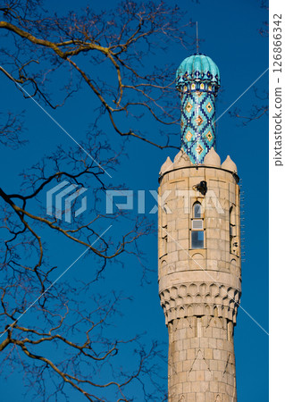 Tower of The blue dome with the golden crescent of the mosque in St.Petersburg - Russia through the branches of trees on a clear spring day 126866342